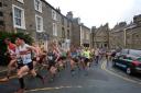 The competitors pass through Settle Market Place, with Wharfedale Harriers' Mark McGoldrick in the middle of the front three runners Picture: Jo Wulf