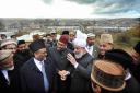 The Ahmadiyya leader Hadhrat Mirza Masroor Ahmad, wearing white turban, is shown around the building
