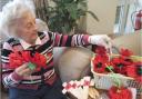 Dales Care Home resident Dorothy Stead, who recently turned 90, helps sort the poppies and crosses for Remembrance Sunday