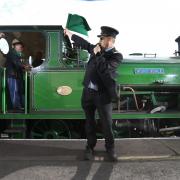 Guard Ken Spence waves off the renamed steam engine. Picture Guzelian