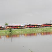 A train travels along the Aire Valley flood plain