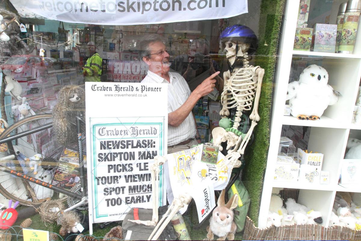 John Botterill, owner of Cool Cards and Gifts, Coach St, Skipton, unveils a fun Tour De France display using a  Craven Herald A board.