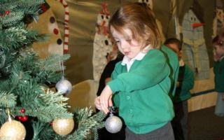 Chayce Telford decorates the school Christmas tree