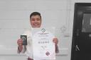 Kamran Hussain stands with his 1st Dan Black Belt certificate