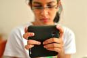 Young Teenage Girl uses her phone to get live-chat support from Guide-Line