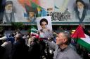 Iranian worshippers walk past a mural showing the late revolutionary founder Ayatollah Khomeini (AP)