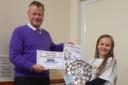 Tim Usherwood of Dacre Son & Hartley presenting Otley Carnival Poster Competition winner Evie Crabtree with her prizes