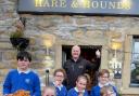 Lothersdale schoolchildren enjoy some tasty onion rings outside the Hare and Hounds
