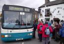 A group of Friends of DalesBus members waiting to board DalesBus 874 outside the Bluebell in Kettlewell