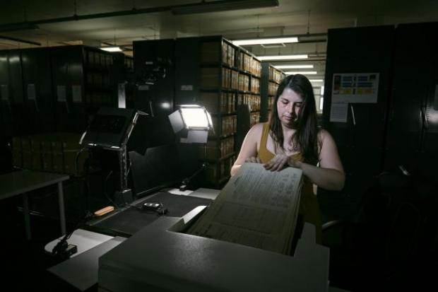 Craven Herald: Photo via PA shows Findmypast technician Laura Gowing scans individual pages of the 30,000 volumes of the 1921 Census at the Office for National Statistics (ONS) near Southampton.