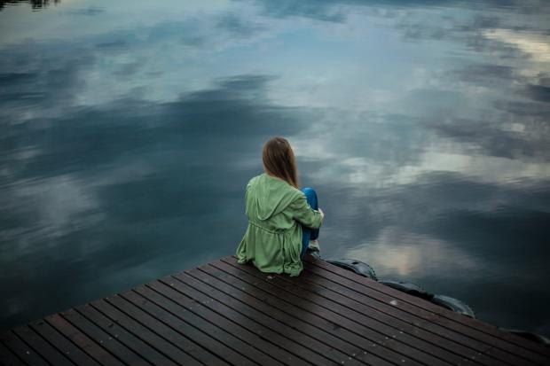Craven Herald: A woman looking out over the water. Credit: Canva