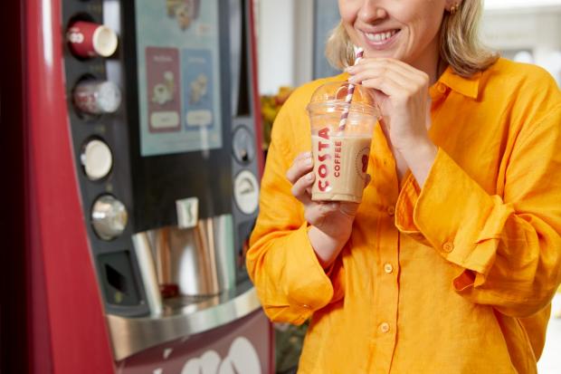 Craven Herald: A person holding a cold drink in front of a new Costa Express machine (Costa Coffee)