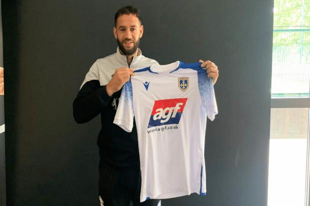 Luke Dean holding the Guiseley shirt after joining the club. Pic: via Guiseley