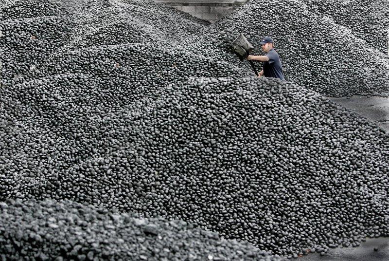 A workman among the tonnes of coal at Redmans Coal Merchants, Ingleton.