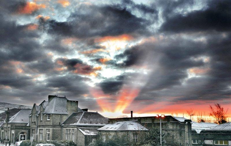 The early-morning sun bursts through the clouds, lighting up Skipton Railway Station.
