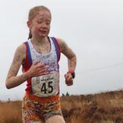 A mud-covered Amelie Lane won the under-15 girls' Withins Skyline race. Picture: Geoff Thompson
