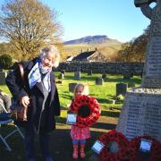 Edith Hudspeth, 3, assists Margaret Barker to lay a wreath for Selside at Horton in Ribblesdale