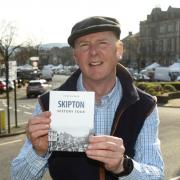 Peter Ellwood with his book at the top of Skipton High Street