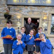 Lothersdale schoolchildren enjoy some tasty onion rings outside the Hare and Hounds
