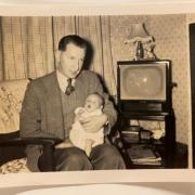 Brian Stott when he was a baby with his dad, Donald, with the type of television set many would have watched the 1953 coronation on