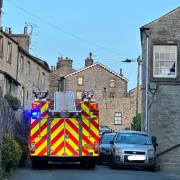Settle fire crew squeezing past parked vehicles in Victoria Street, Upper Settle, on the way to a call-out