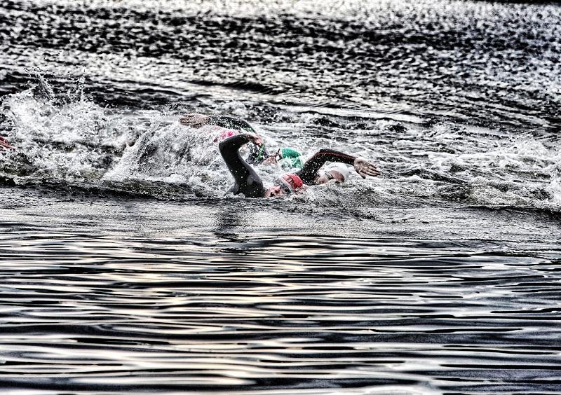 Members of the Craven Energy Triathlon club are captured powering across the icy waters of Coniston Lake 