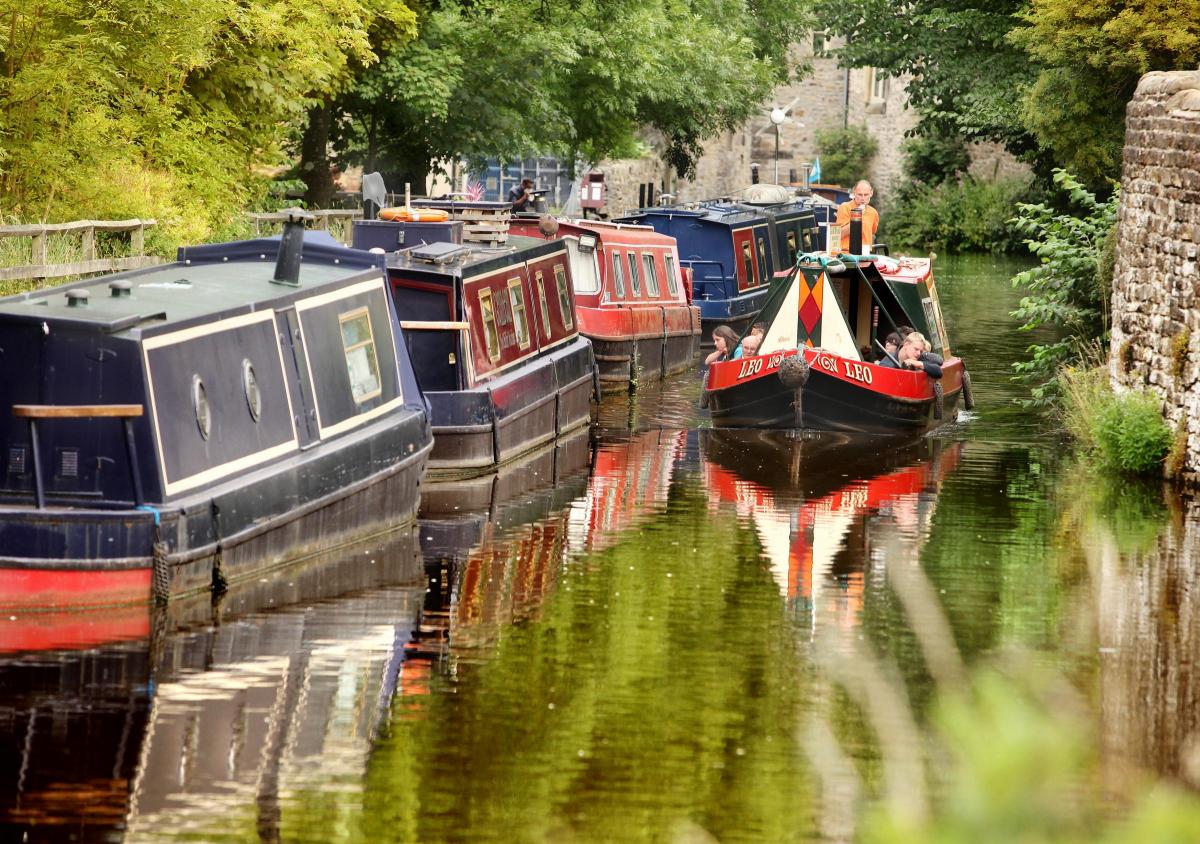 Golden colours reflect around a  pleasure cruiser as it takes day trippers along the historic Springs Canal in Skipton