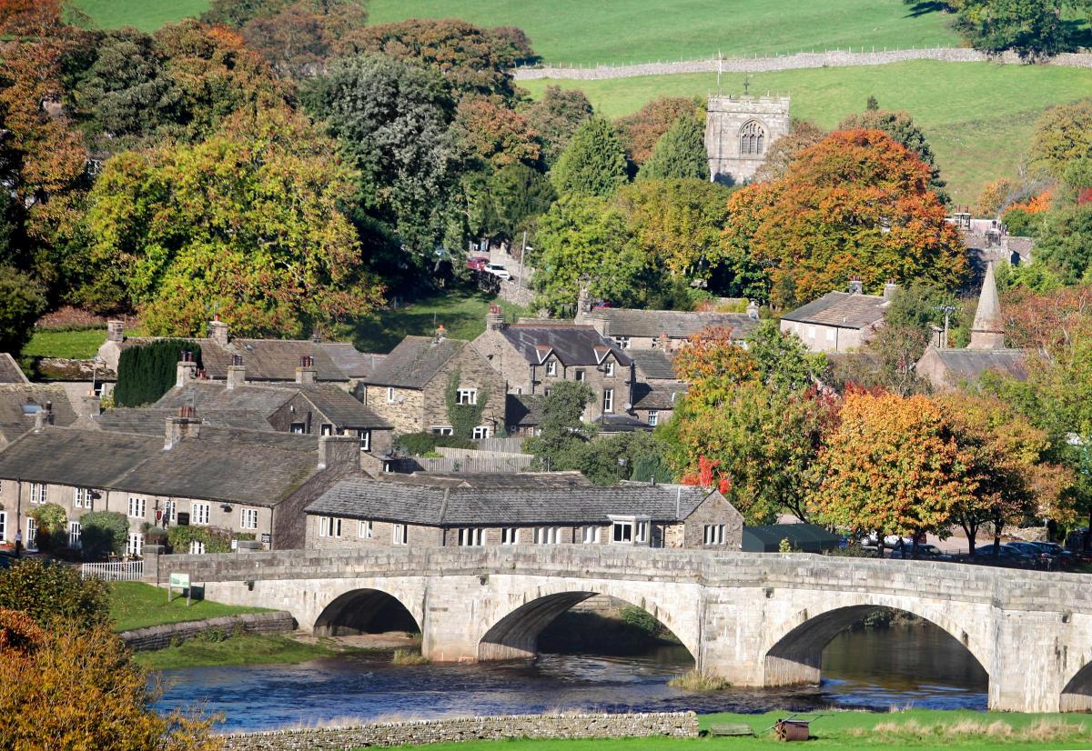 The picturesque village of Burnsall and the bridge over the Wharfe are beautifully framed by autumnal colours of the trees. 