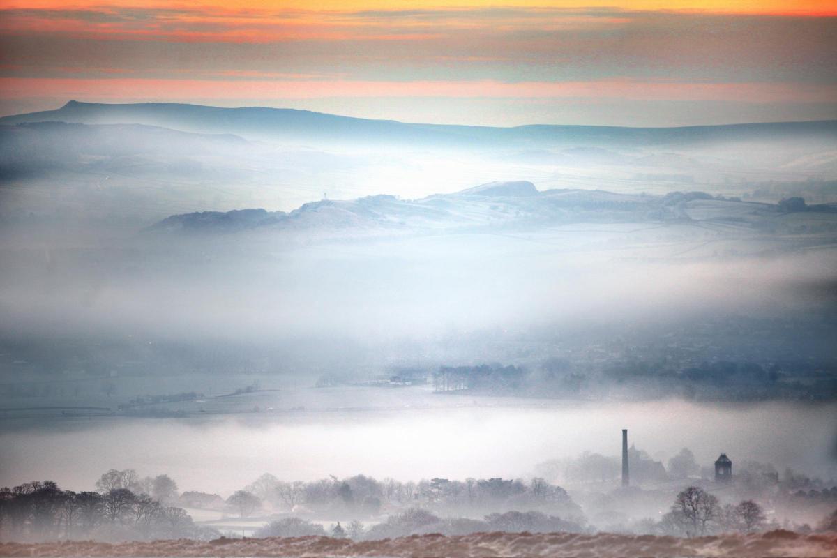 Layers of mist fill the Aire Valley with the majestic mill chimney of Carleton-in-Craven, peeping out of the foreground haze